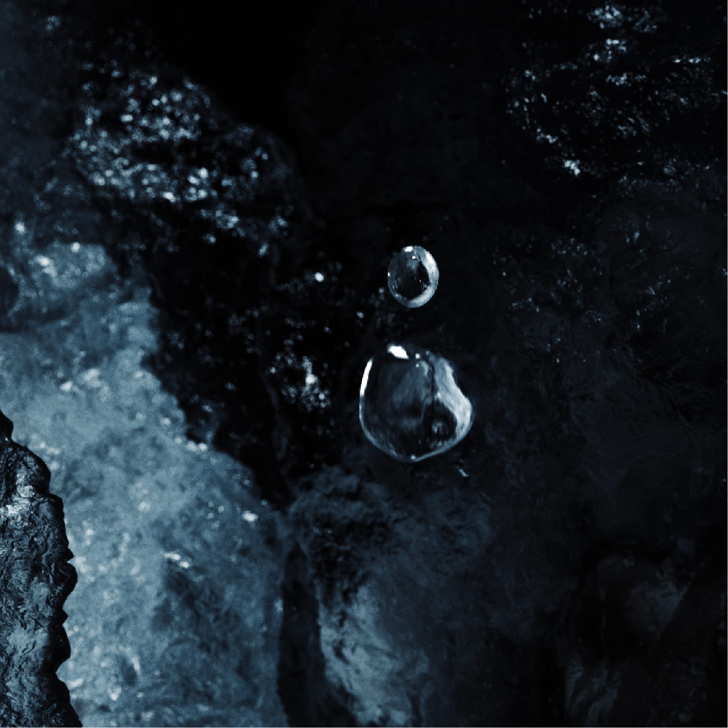 暗い青と黒を基調とした氷の表面がクローズアップされている